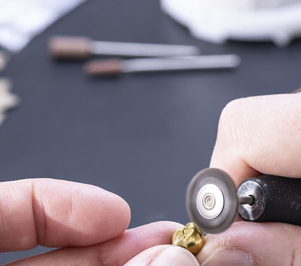 Gold crown next to unprocessed gold platelet of the alloy Esteticor Helvetica 